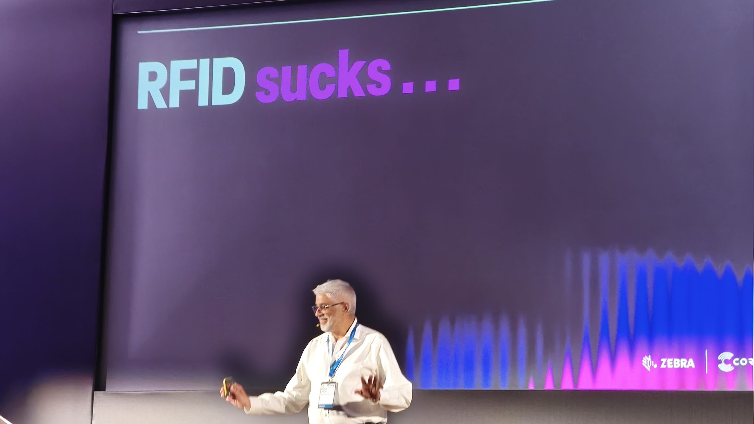 Philip Leslie, CEO of Coriel Solutions stands in front of a presentation screen with the title: 'RFID Sucks...'